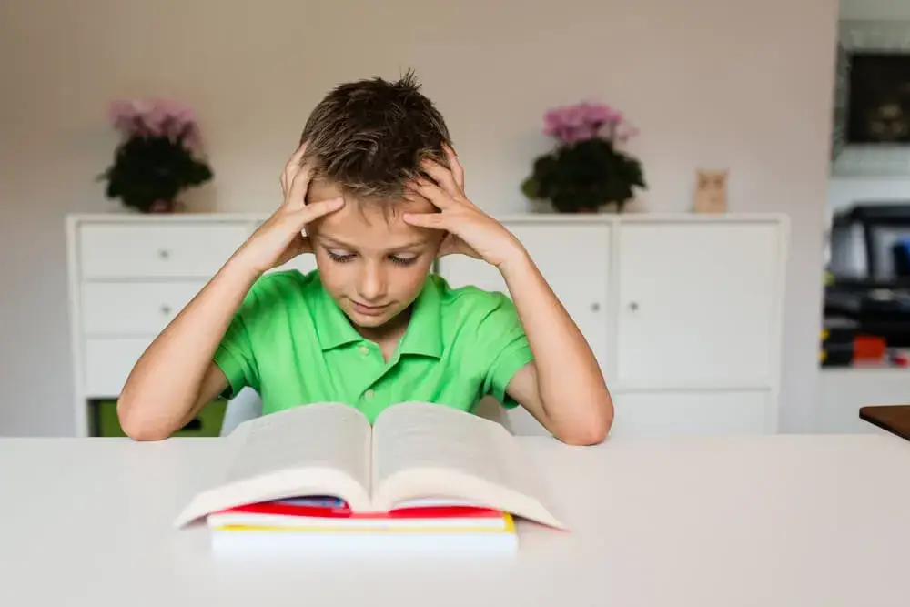 dziecko mające trudności z czytaniem książki, artystyczne ujęcie